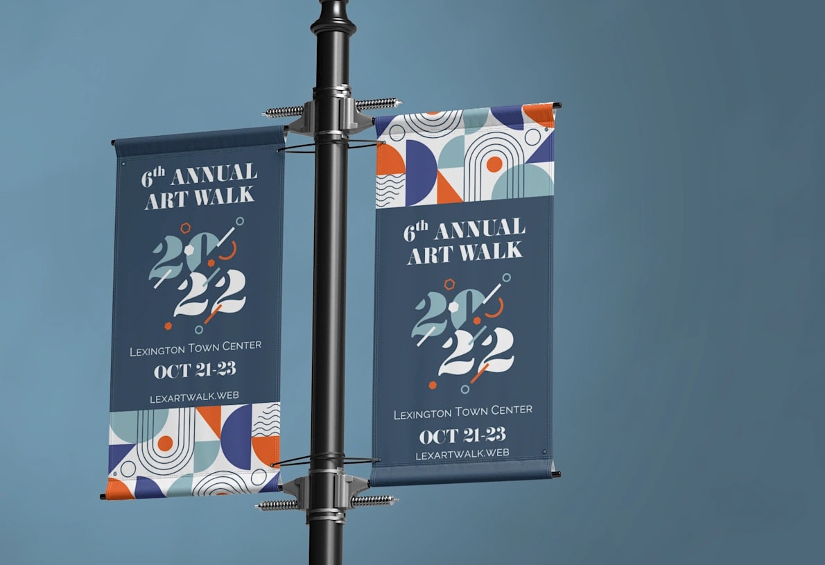 Bannières de façade faisant la promotion d’une promenade artistique annuelle attachées de chaque côté d’un lampadaire.