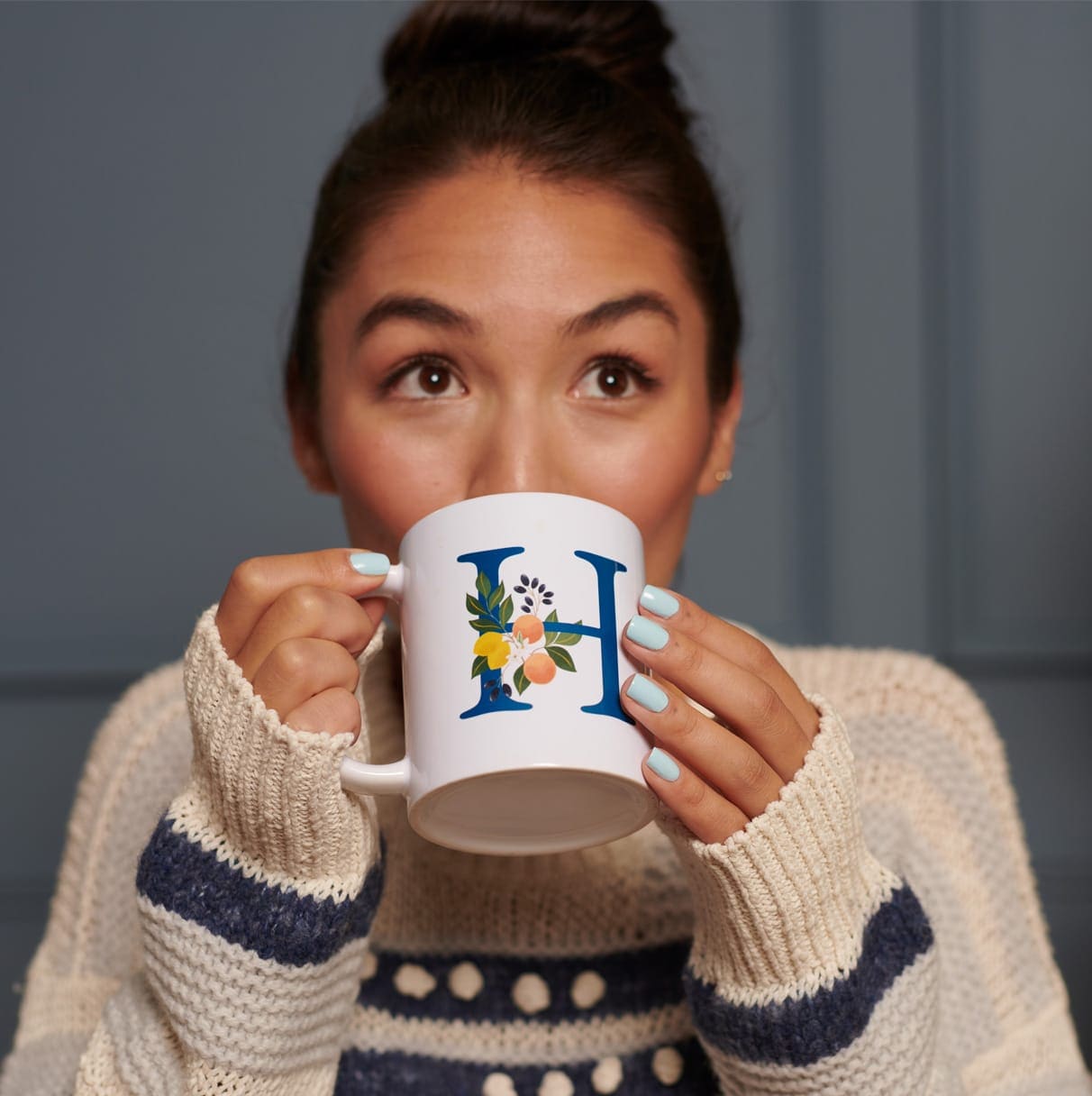 Une femme buvant dans un mug personnalisé