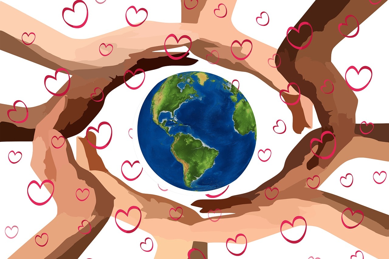 different colored hands surrounding the world