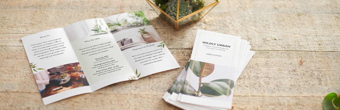 A business's trifold brochures are shown on a tabletop, one is opened with content to read and is beside a pile of folded ones.