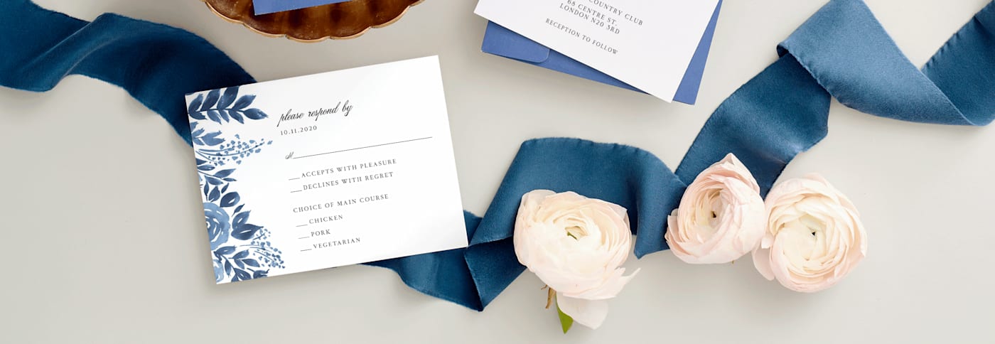 Elegant RSVP for a wedding invitation, floreal theme, blue decoration ribbon and roses on a table.