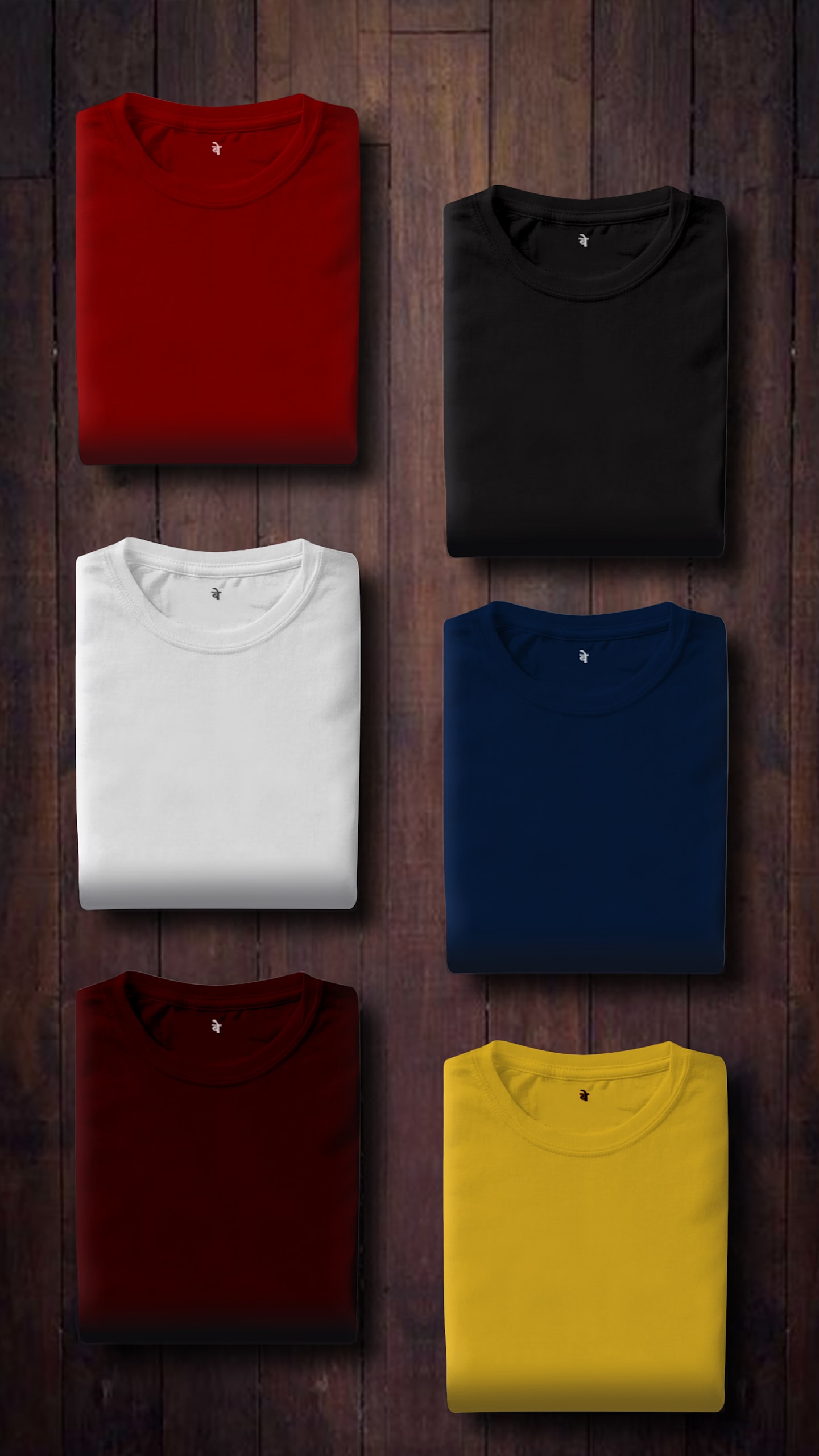 Verschiedenfarbige Shirts liegen gefaltet auf einer Holzplatte