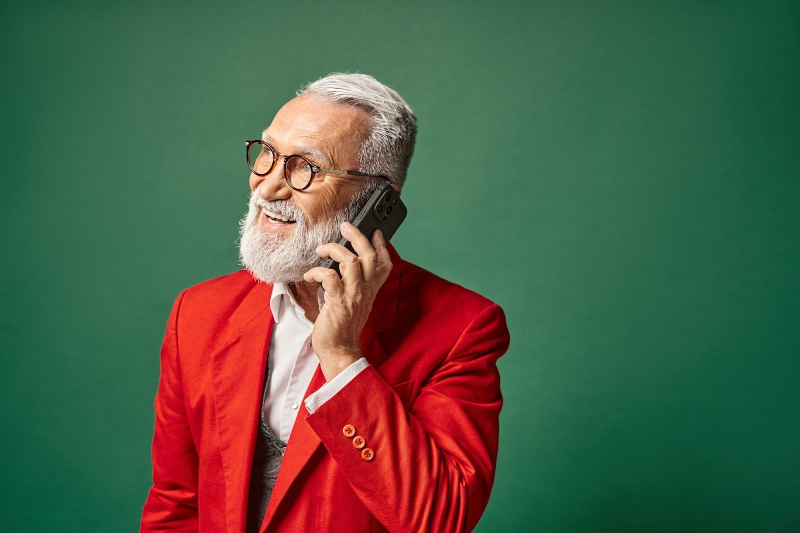 An elderly man that resembles modern Santa speaking on the phone
