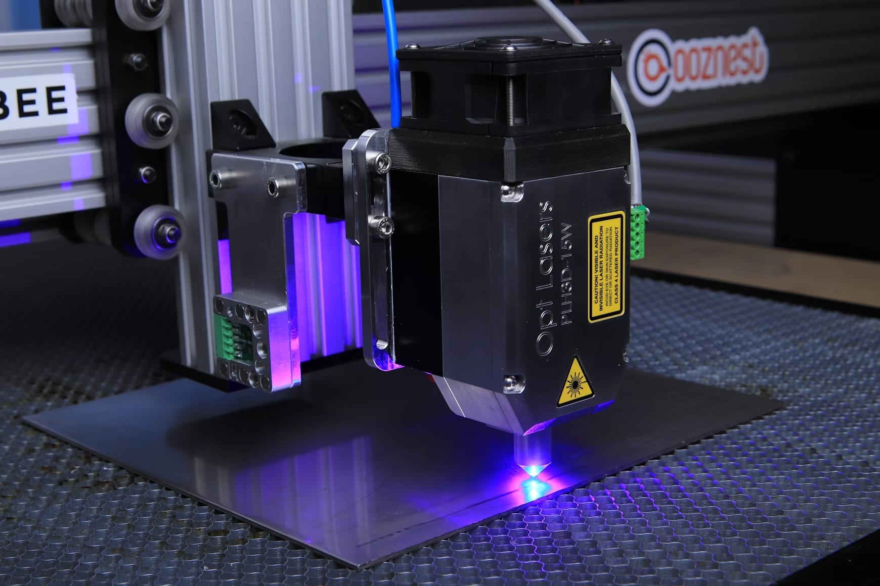 Nahaufnahme einer Lasergravurmaschine beim Druck mit lilafarbenem Laser auf eine Metallseite