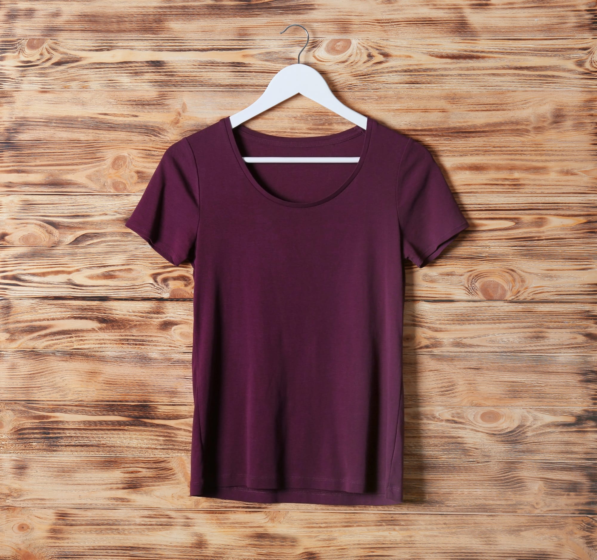 Burgundy color T-shirt on a hanger