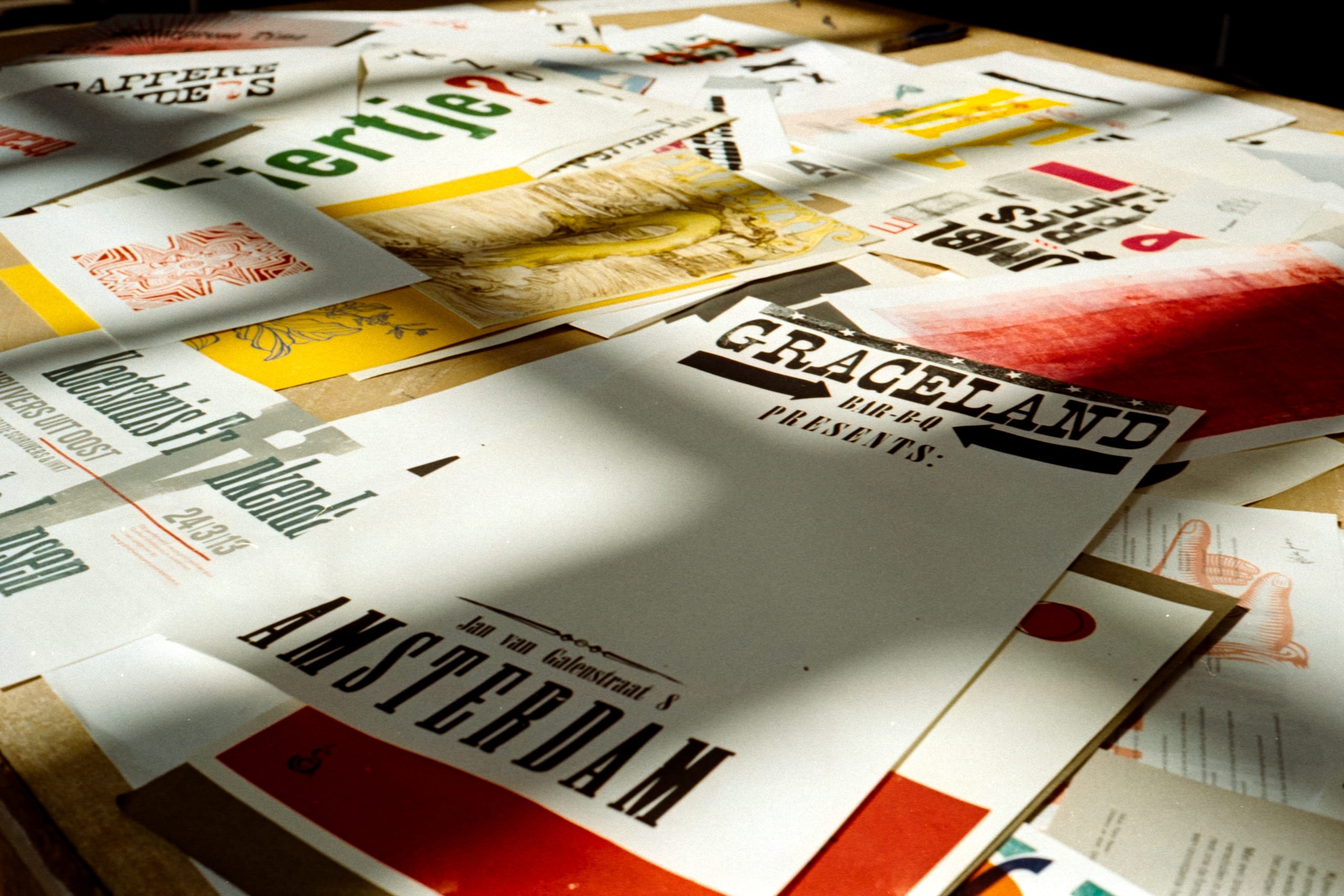 Wooden table littered with flyers.