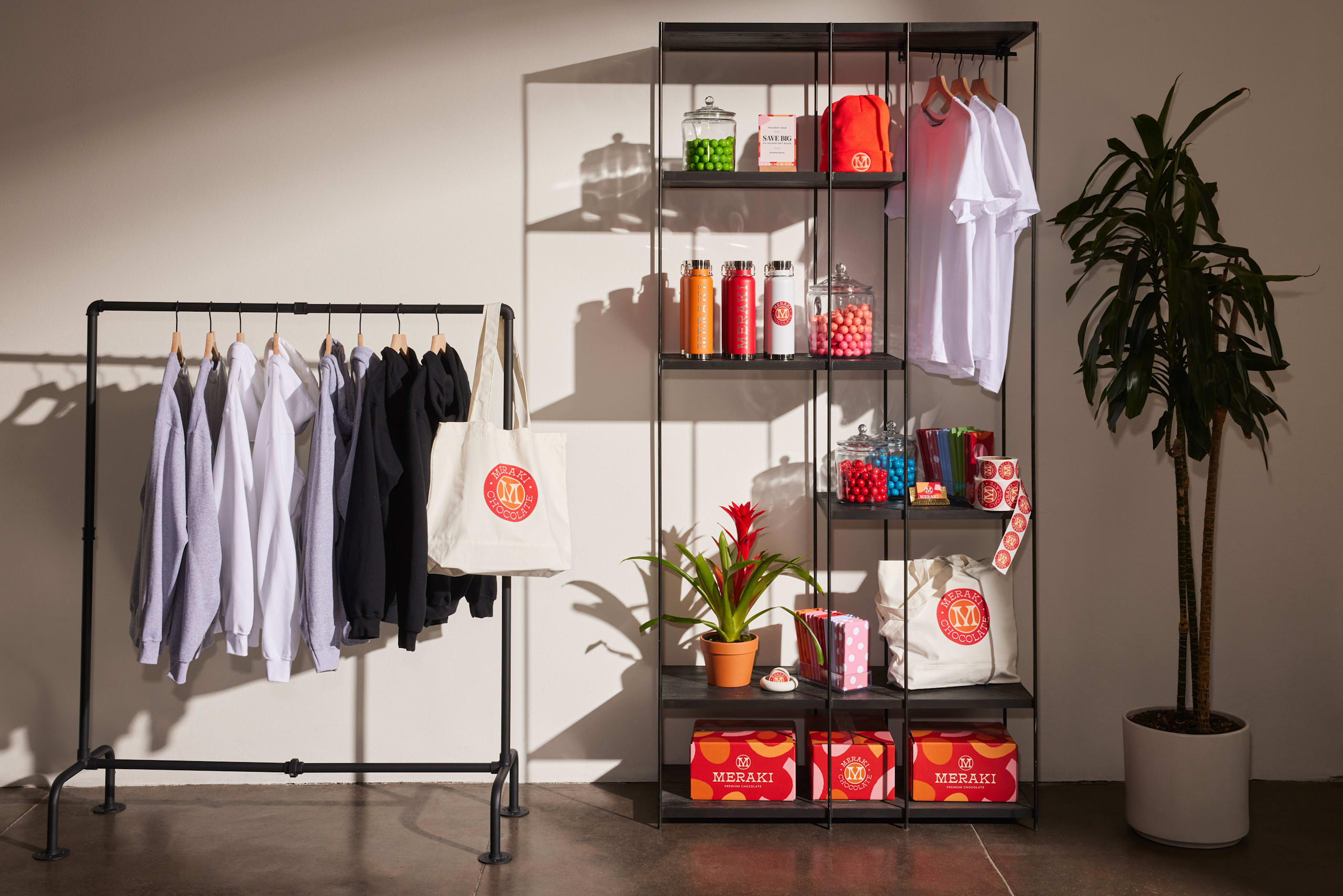 A clothing rack with hanging t shirts with custom designs.