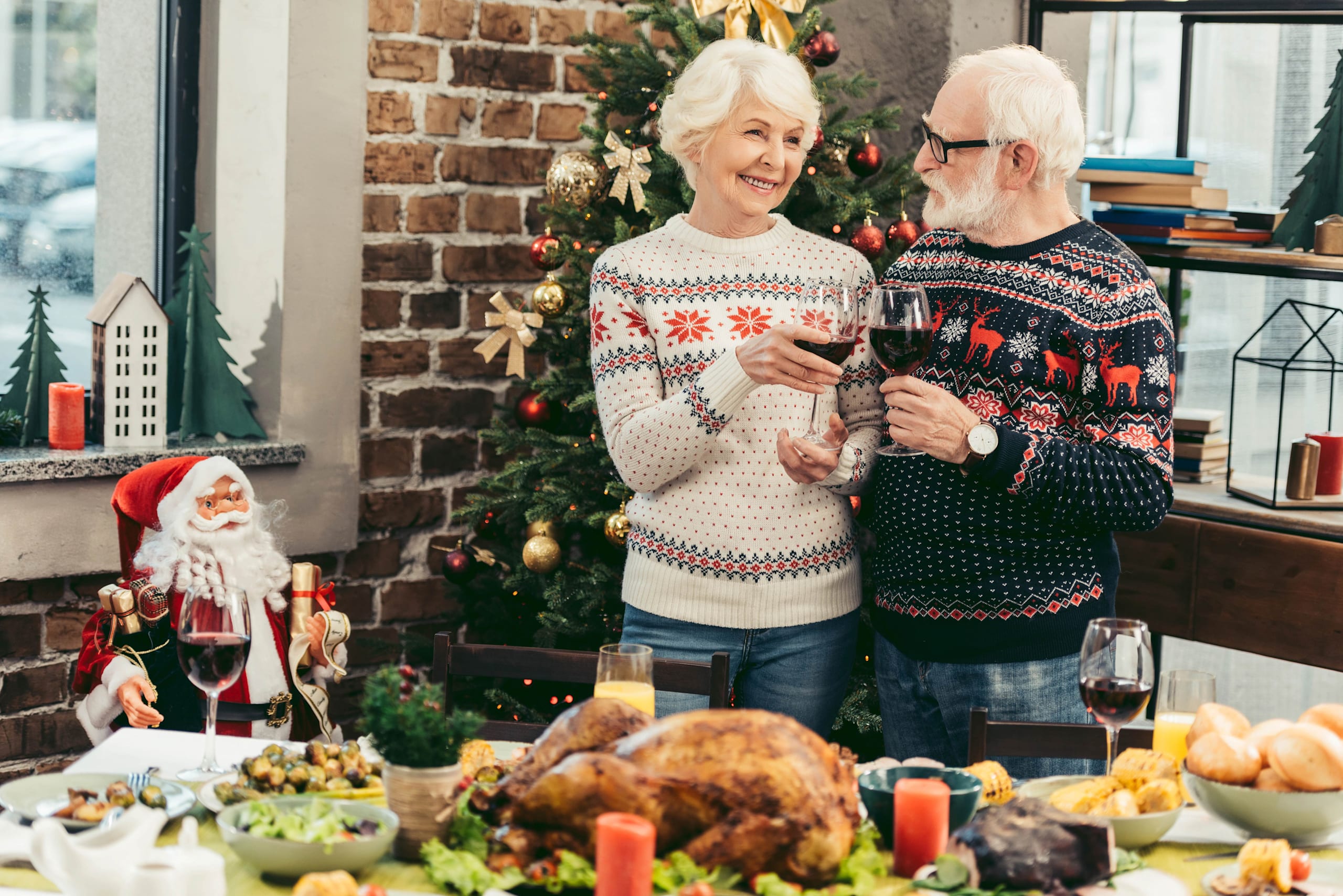 Senior couple clinking wine glasses during winter holidays