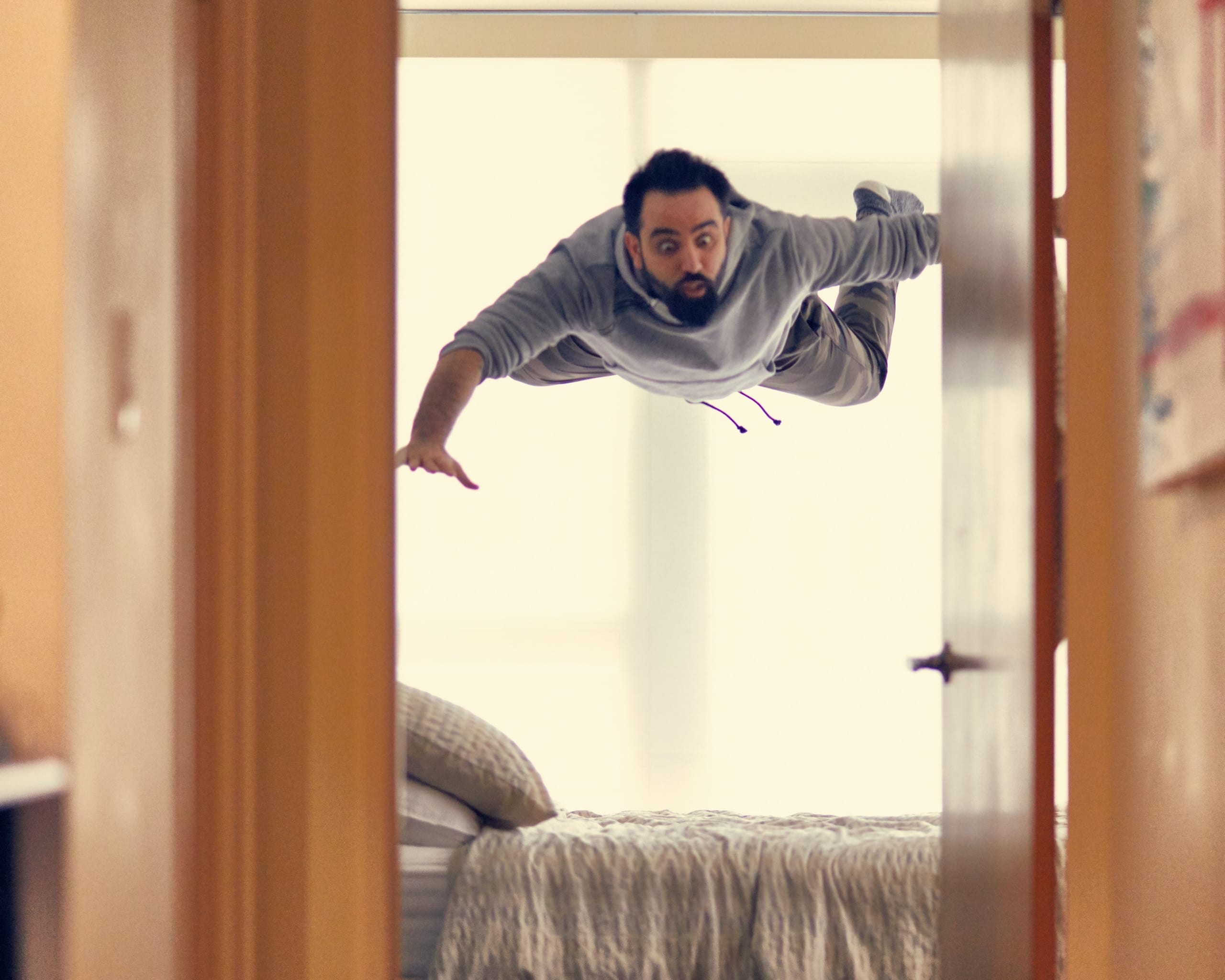 Homme tombant du plafond sur son lit