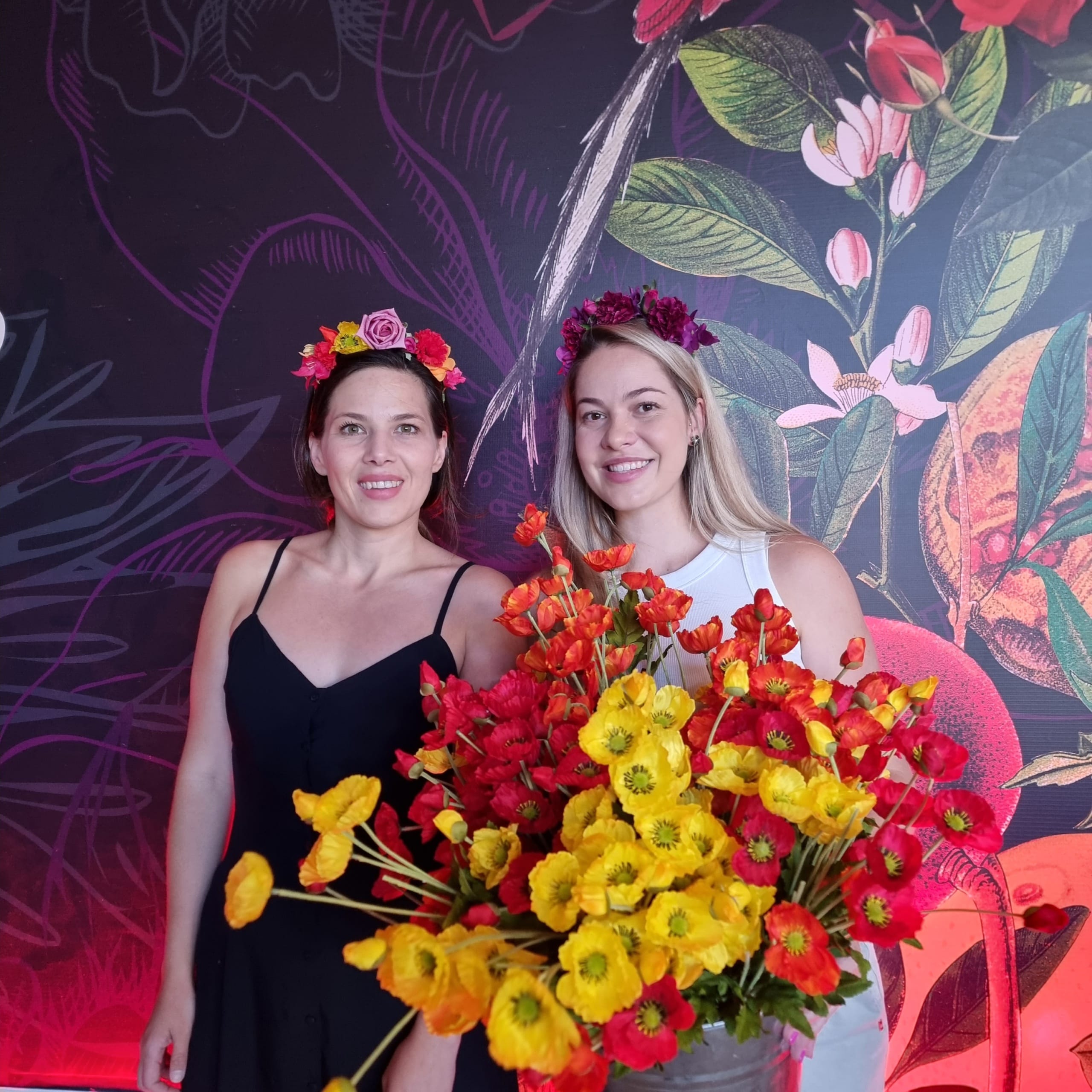 Levonne Marais and Mignon Malherbe, holding a big bunch of yellow, red and orange flowers