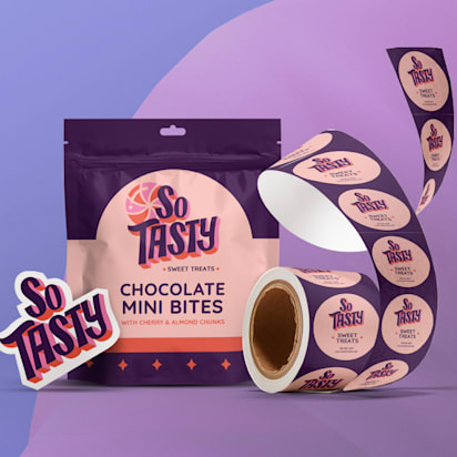 A colourful package of "So Tasty" chocolate mini bites is featured with a background of its brand colours - indigo, purple and a peach pink. The image also features a roll of similarly branded circle stickers, demonstrating VistaPrint product offering.
