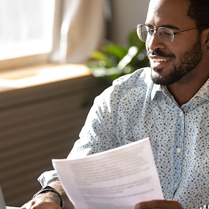 A small business owner smiles getting paperwork in order