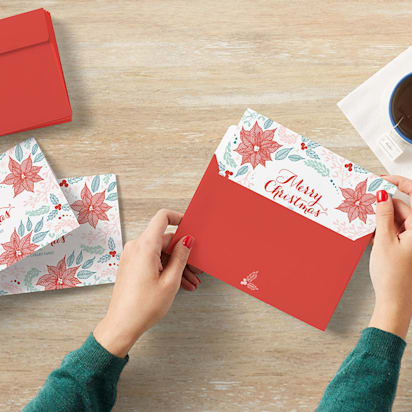 top view of signing and sealing Christmas cards at a desk with a coffee