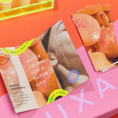 Colorful brochure and flyers on display table with bold images and typography, showcasing modern graphic design layout