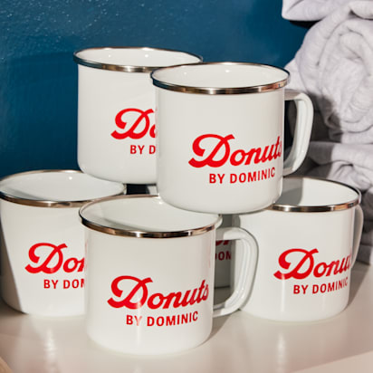 white mugs with retro red text brand name placed on top of each other