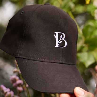 Black cap with white 'B' letterform embroidered..