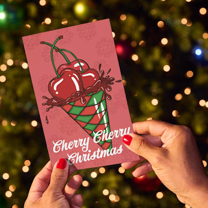 hands hold card in front of Christmas tree