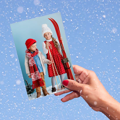 hand holds photo of kids dressed in ski clothes