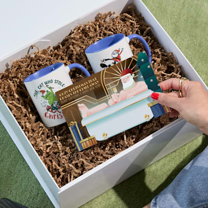 Hand opening gift basket to see Christmas card
