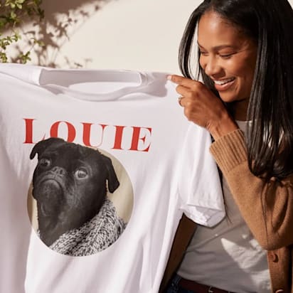 person holds up t-shirt design featuring "Louie" the bulldog