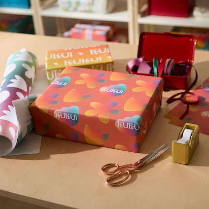 Wrapped gifts laying with colorful wrapping paper on a table.