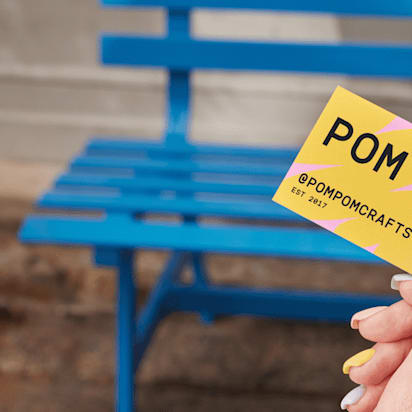 Female hand holding a colorful business card with company name and social contact – how to make business cards on Word.