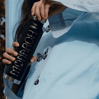 Person holding a customized water bottle while twisting the cap – water bottle design ideas.