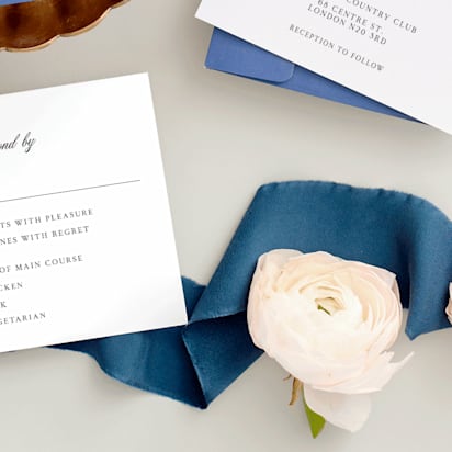Elegant RSVP for a wedding invitation, floreal theme, blue decoration ribbon and roses on a table.