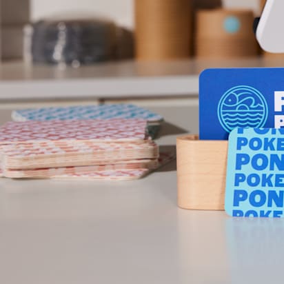Elegant and original business card design resembling playing cards, displayed on a candle-decorated table in soft, calming tones.