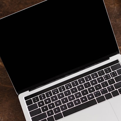 Above images of an open but dark screened laptop, on a desk beside a cup of coffee.