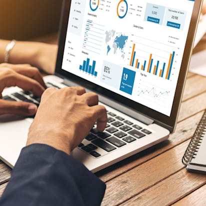 Male and female hands analyzing website traffic data using documents, notebooks, and a laptop — google tag management concept.
