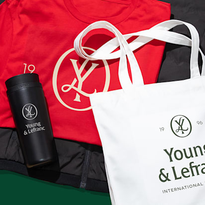 A top down image of a festively colored and branded tshirt, water bottle and tote bag