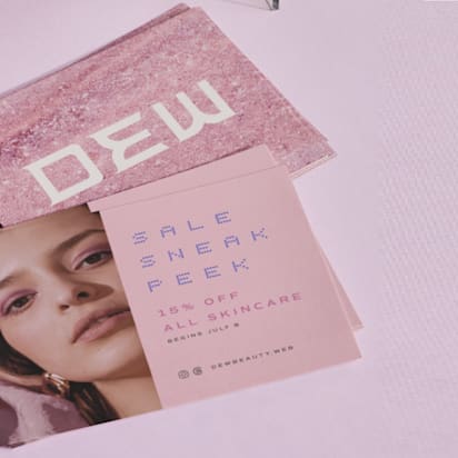 Stack of branded skincare postcards featuring a model, promotional offer, and pink-toned design – example of postcard marketing.
