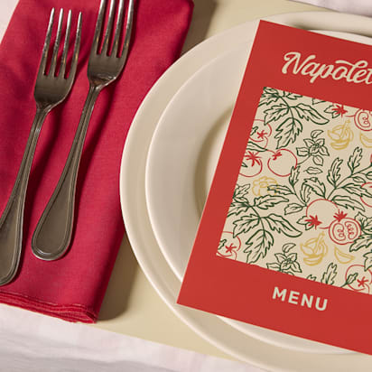 Bi-fold menu placed on plates at a restaurant