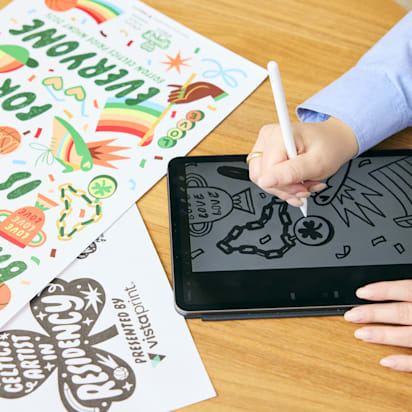 Person sketching on a graphic tablet at a wooden desk, illustrating the elements of design in action.