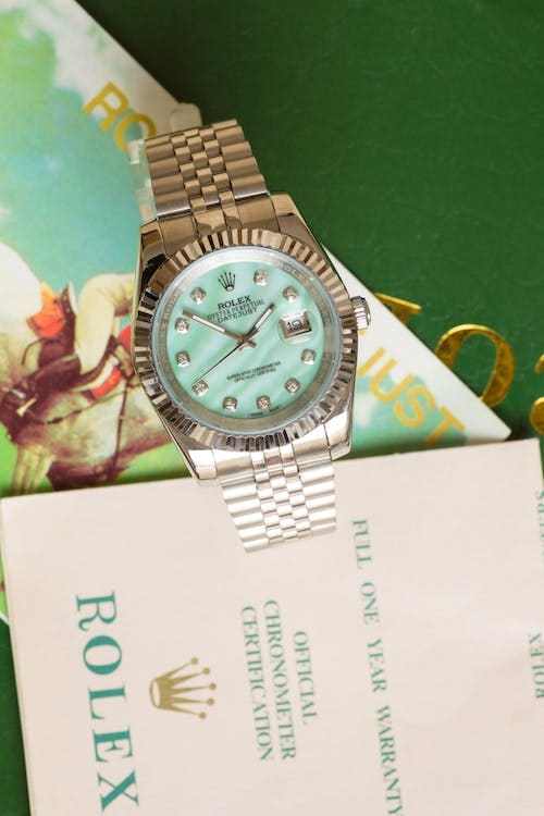 A Rolex watch next to a Rolex brochure