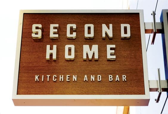 A textured, wooden sign for a kitchen and bar