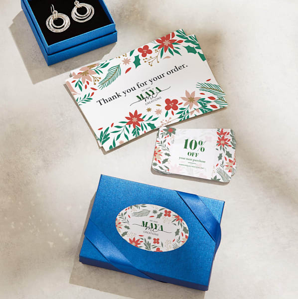 Example of branded packaging with elegant blue boxes and ribbon complete with custom stickers and promo materials in red, white and green