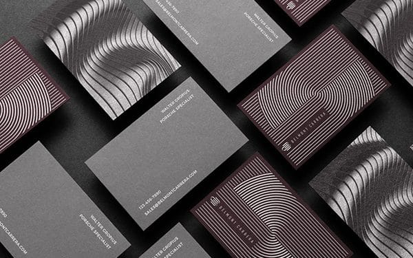 multiple images of ridged, reflective business cards in shades of maroon