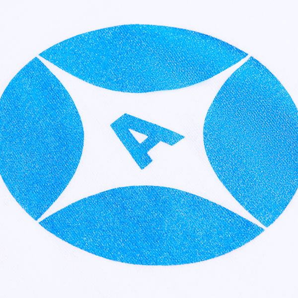 A close-up of a blue circle with a white star inside of it and letter &ldquo;A&rdquo; applied to fabric through screen printing