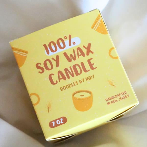 Yellow logo printed on candle packaging