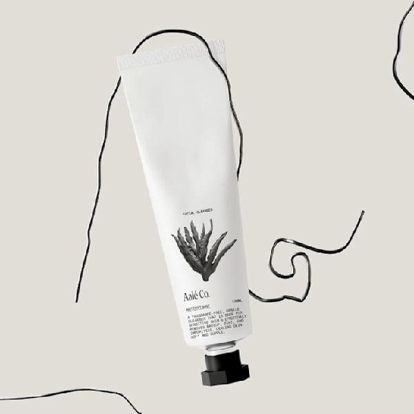 An example of the Apothecary Aesthetic packaging trend 2026: minimalist skincare tube with monochrome apothecary-style label featuring a hand-drawn aloe illustration, clean typography and a soft neutral background