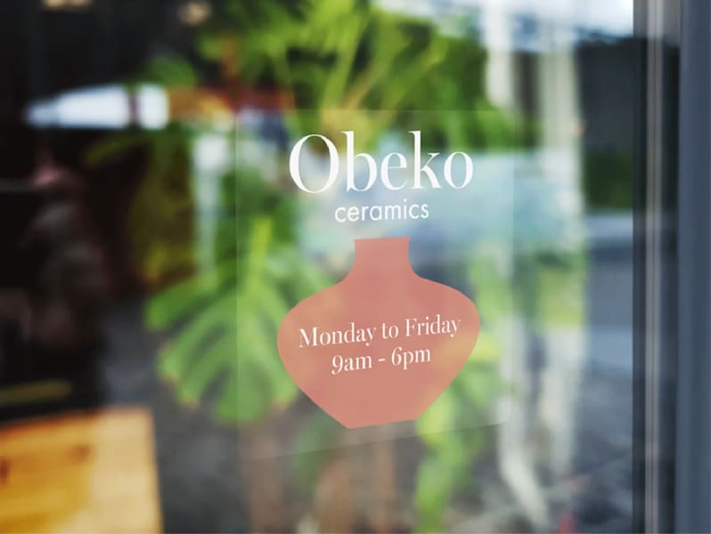 Window decal sign showing ceramics shops business hours.