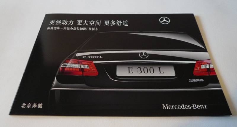 The rear of a black Mercedes-Benz on a black backdrop