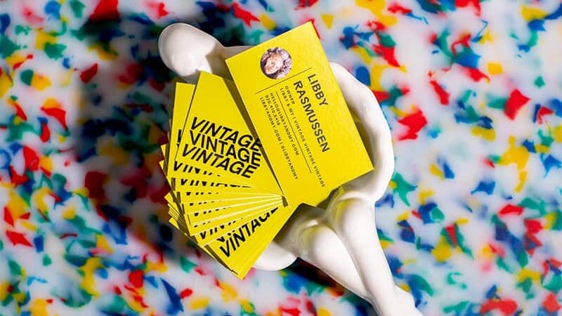 Stack of bright yellow business cards with bold black text reading “Vintage Vintage Vintage”
