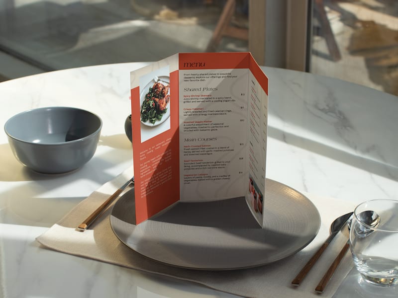 Menu de restaurant triptyque posé debout sur une assiette
