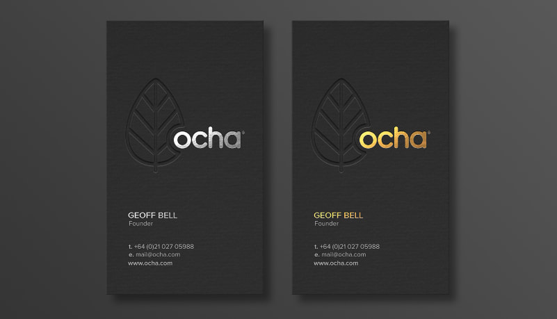 Print marketing materials: two black business cards side by side, one with gold metallic text and the other with silver