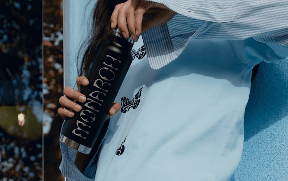 Person holding a customized water bottle while twisting the cap – water bottle design ideas.