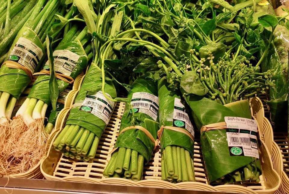 Groceries packed in banana leaves in a store display.