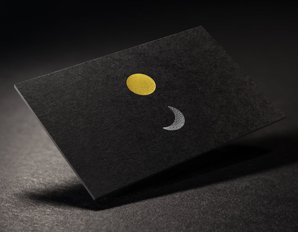 Black business card with a sun and moon logo